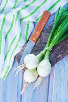 fresh onion and knife on the wooden table