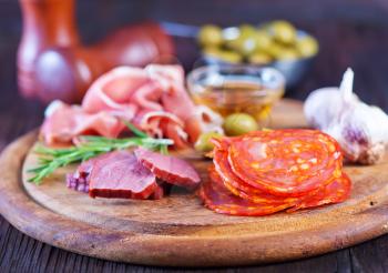 salami, sausages and ham on the wooden board