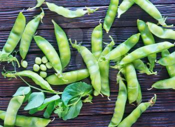 green peas on a table, fresh peas on the wooden background