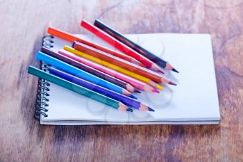 color pencils and note on the wooden table