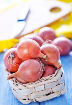 raw onion in basket and on a table