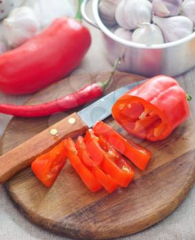 Raw red peppers on the wooden board