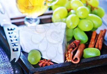 camembert cheese with green grape on the wooden board