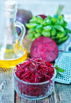 grated beet in bowl and on a table