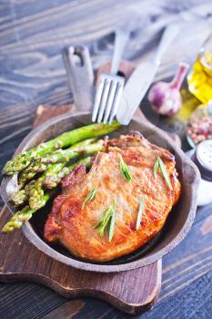 fried meat with asparagus in the pan