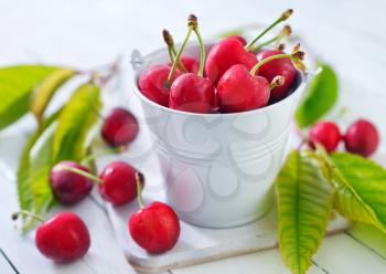 cherry fruits in white bucket and on a table