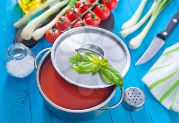 tomato soup in metal bowl and on a table