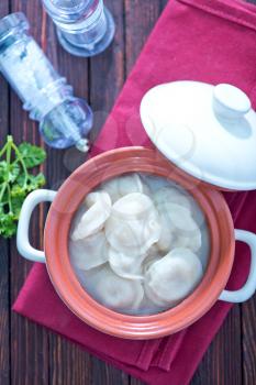 pelmeni with meat in bowl and on a table