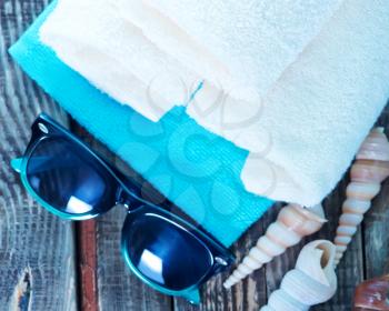 white towels, sea shells and sunglasses on a table