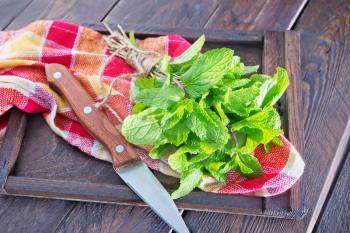 fresh mint in wooden board and on a table