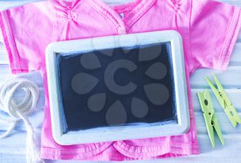 baby clothes and black board on a table