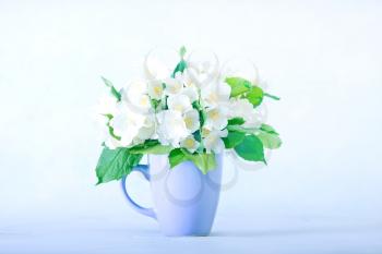 a bouquet of jasmine in a cup on a white table