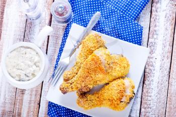 fried chicken legs on plate and on a table