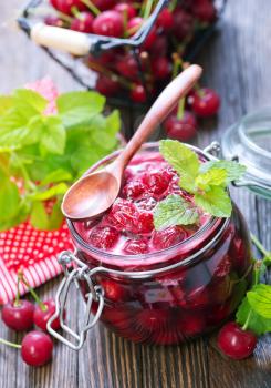 cherry jam and fresh berries on a table