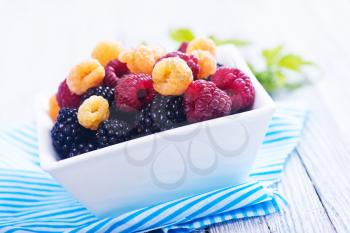 fresh berries in bowl and on a table