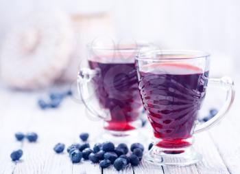 blueberry juice in glass and on a table