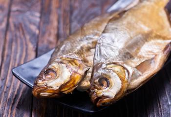 smoked fish on plate and on a table