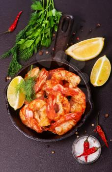 fried shrimps in pan and on a table