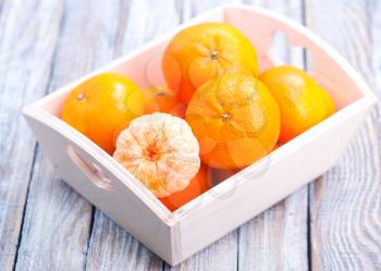 fresh tangerines in wooden box and on a table