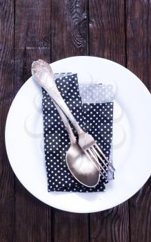 Dishes in kitchen. Knife, spoon and fork with serviette over dish