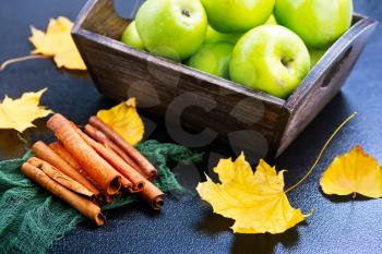 green apples and cinnamon on a table