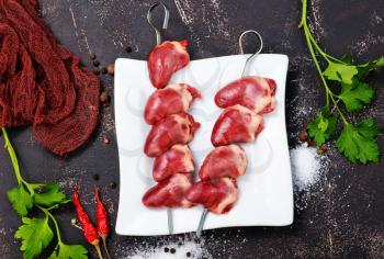 raw duck hearts with spice and salt on a table