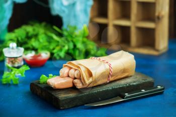 fresh sausages in paper and on a table