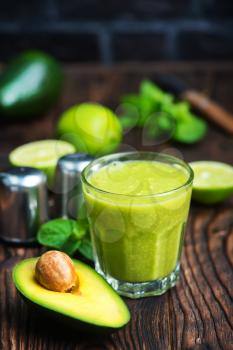 fresh avocado smoothie in glass and on a table