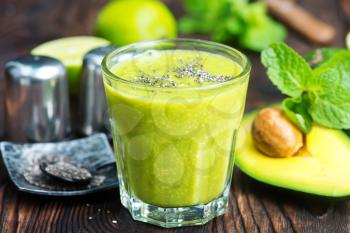 fresh avocado smoothie in glass and on a table