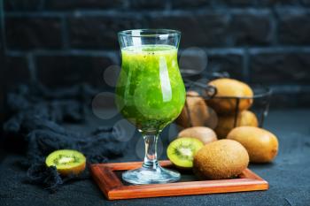 kiwi smoothie in glass and on a table