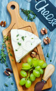 cheese with grape and walnuts on the board