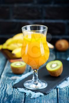 juice from kiwi and banana in the glass and on a table