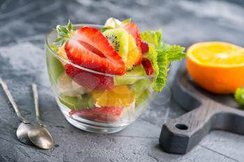fruit salad in glass bowl and on a table