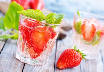 strawberry drink in glass and on a table