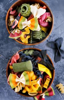 color raw pasta in bowl and on a table