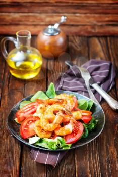 salad with shrimps on plate and on a table