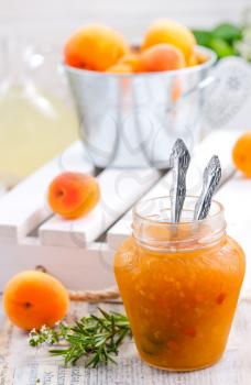 apricot jam in glass jar and on a table