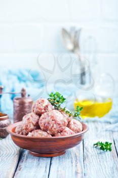 raw meatballs with spice and salt on a table