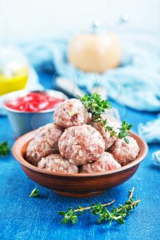 raw meatballs with spice and salt on a table