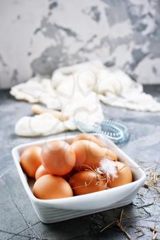 raw eggs in bowl and on a table