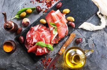 prosciutto with olives and spice on a table