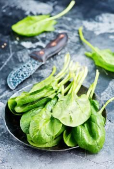 fresh spinach on plate and on a table