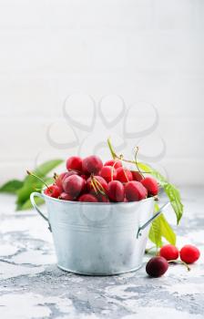 fresh cherry in metal bowl and on a table