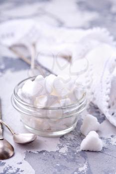 white sugar in glass bowl and on a table