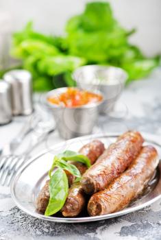 raw sausages with spice on the metal plate