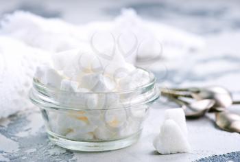 white sugar in glass bowl and on a table