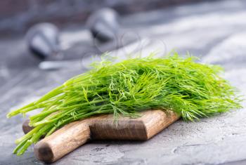 fresh dill on board and on a table