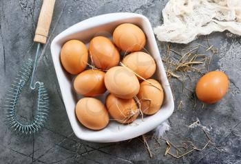 raw eggs in bowl and on a table