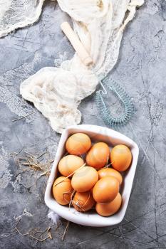 raw eggs in bowl and on a table