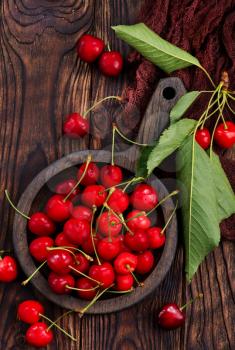 red cherry in bowl and on a table